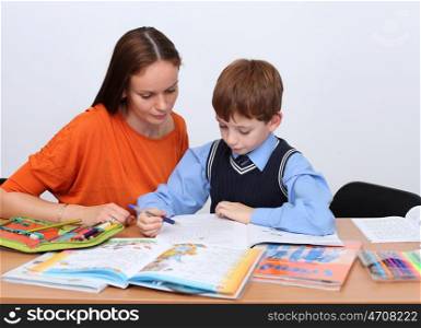 mother or teacher helping kid with schoolwork