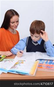 mother or teacher helping kid with schoolwork
