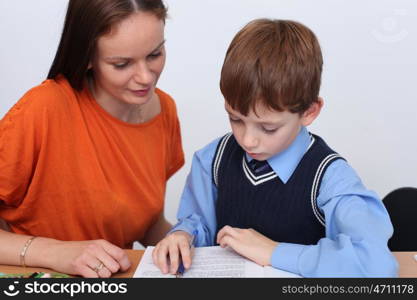 mother or teacher helping kid with schoolwork