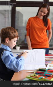 mother or teacher helping kid with schoolwork