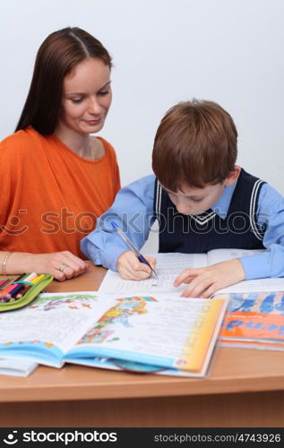 mother or teacher helping kid with schoolwork