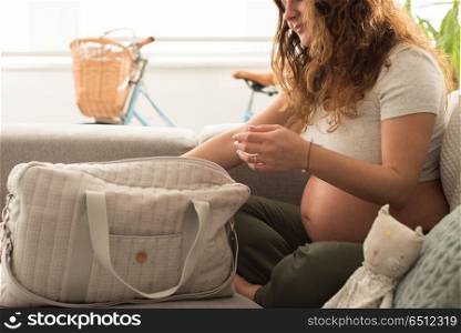 Mother organizing maternity bag. Young mother organizing the baby maternity bag