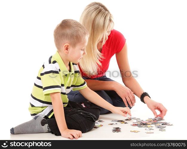 mother playing puzzle together with her son on floor isolated on white background