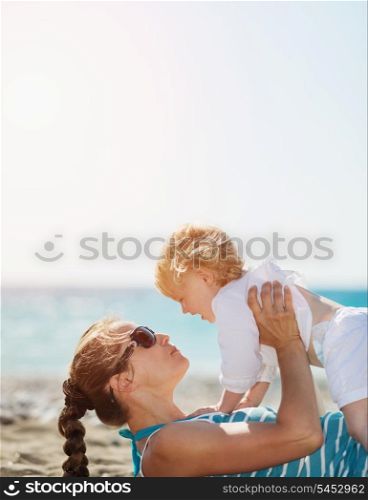 Mother playing with baby on beach
