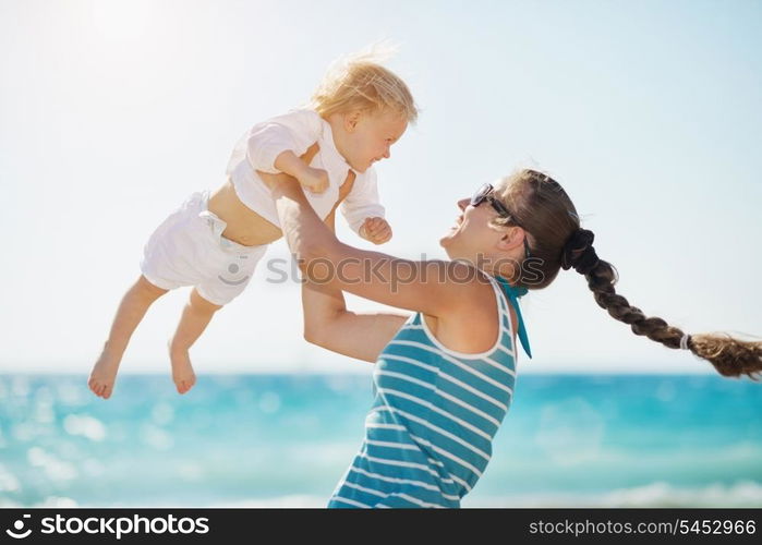 Mother playing with baby on beach