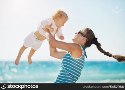 Mother playing with baby on beach