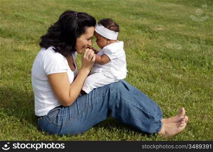 Mother playing with her daughter on the grass