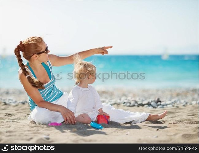 Mother pointing baby on copy space