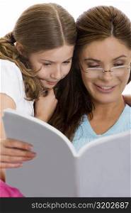 Mother reading a magazine with her daughter