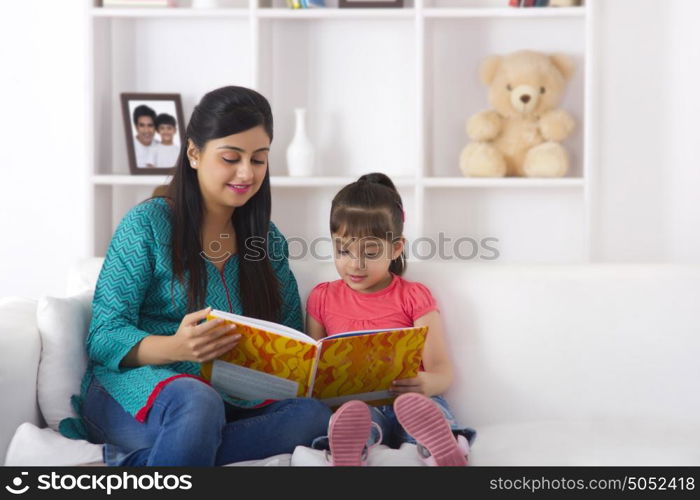 Mother reading a storybook to daughter