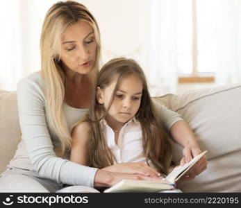 mother reading book daughter home