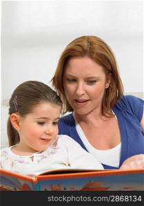 Mother Reading Book to Daughter