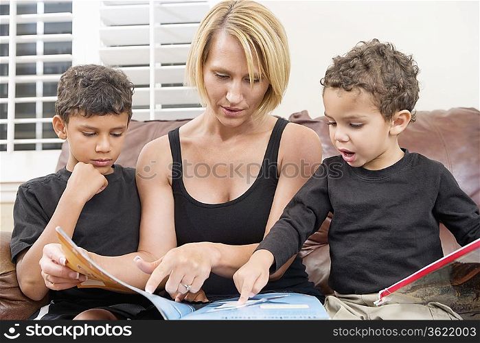 Mother reading book with two children