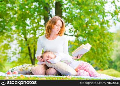 mother reads her daughter&rsquo;s interesting book on the nature