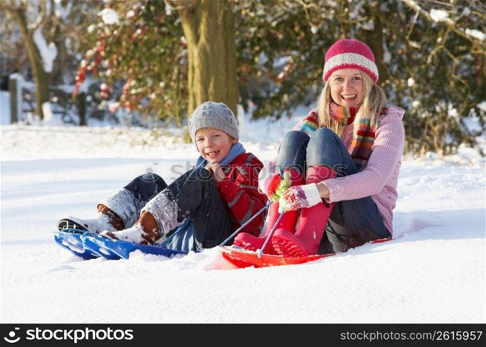 Mother Riding On SledgesThrough Snowy Landscape