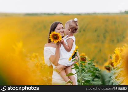 mother&rsquo;s day. Happy mother with the daughter in the field with sunflowers. mom and baby girl having fun outdoors. family concept. mother&rsquo;s day. Happy mother with the daughter in the field with sunflowers. mom and baby girl having fun outdoors. family concept.