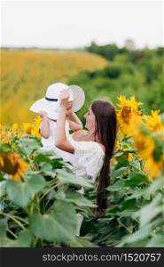 mother&rsquo;s day. Happy mother with the daughter in the field with sunflowers. mom and baby girl having fun outdoors. family concept. mother&rsquo;s day. Happy mother with the daughter in the field with sunflowers. mom and baby girl having fun outdoors. family concept.