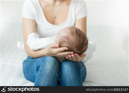 Mother&rsquo;s hands holding head of sleeping 3 months old baby boy