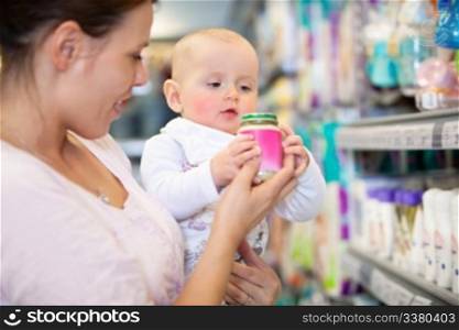 Mother shopping with baby in a supermarket, shallow depth of field - focus on baby