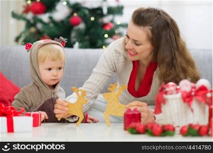 Mother showing baby Christmas deer shaped cookies