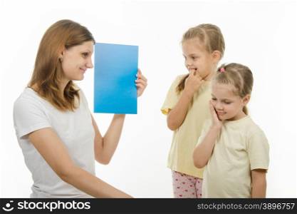 Mother shows two daughters plain color pictures, checking whether they distinguish colors