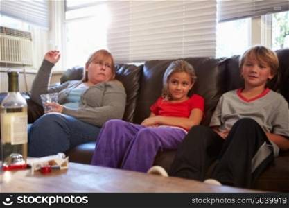 Mother Sits On Sofa With Children Smoking And Drinking