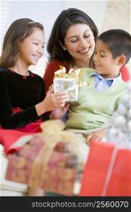 Mother Sitting With Her Son And Daughter,Exchanging Christmas Gifts