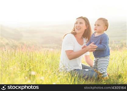 Mother sitting with young son in field