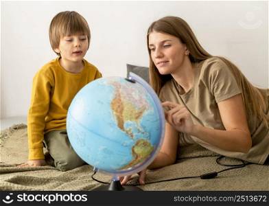mother son looking globe together
