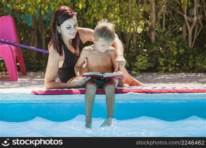 mother son sitting by pool reading