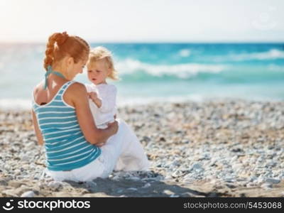 Mother spending time with baby on beach