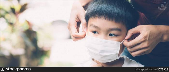 Mother take care son with face mask for protection disease flu or covid-19 outdoors, mom wearing on medical mask with child safety for protect outbreak of pandemic, medical concept, banner website.