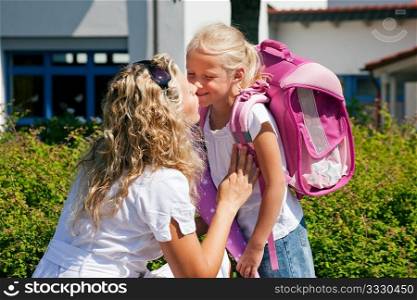Mother taking her daughter to school, saying her goodbye for the day