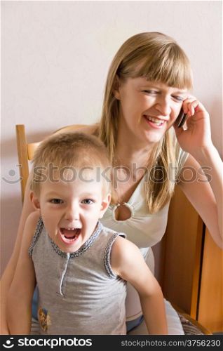 Mother talking by mobile phone and angry son