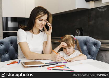 mother talking phone helping her daughter