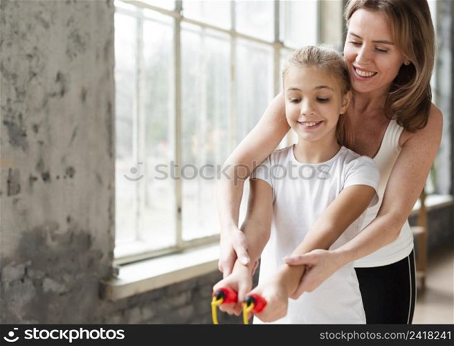 mother teaching daughter how use jump rope