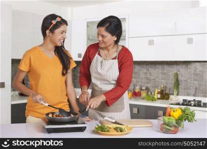 Mother teaching daughter to cook