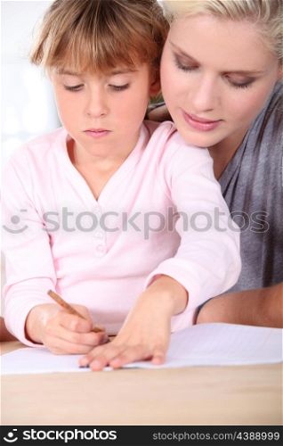 Mother teaching daughter to write