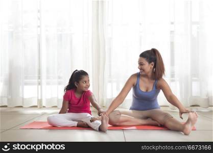 Mother teaching exercise to her daughter