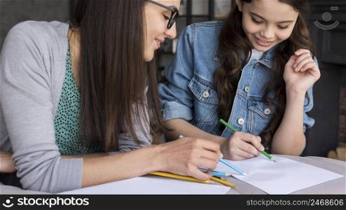 mother teaching girl draw
