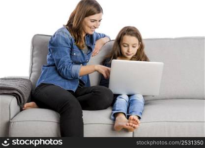 Mother teaching her little daughter working with a laptop