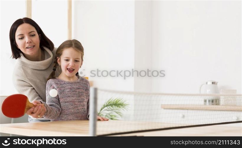 mother teaching kid ping pong