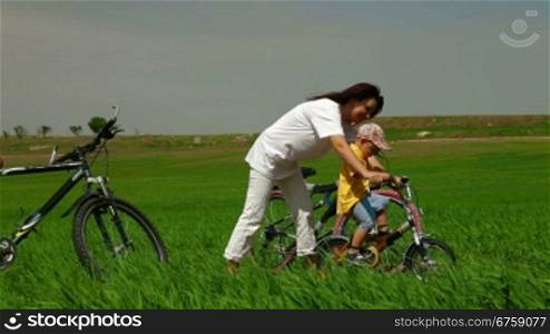 Mother teaching toddler to ride a bike