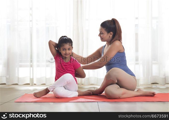 Mother teaching yoga to her daughter