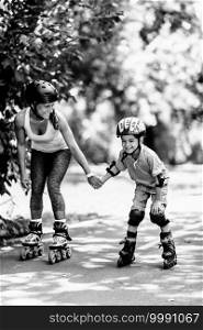 Mother teching son roller skating in park