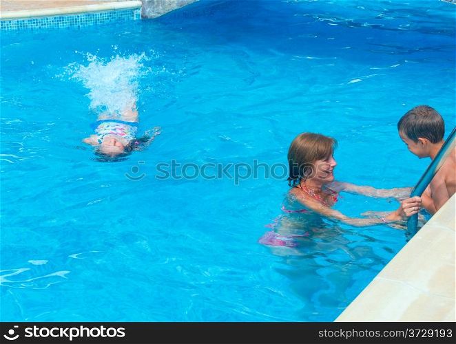 Mother train children to swim in the pool.