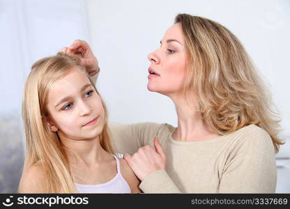 Mother treating daughter&acute;s hair against lice