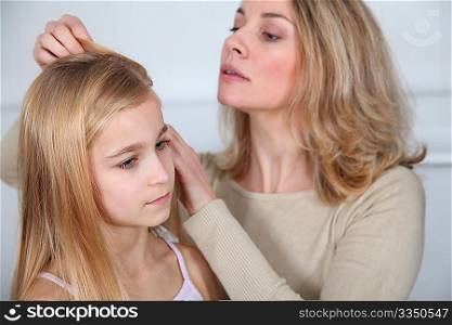 Mother treating daughter&acute;s hair against lice
