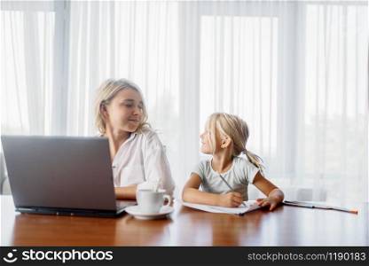 Mother uses laptop at home, child looks at her. Parent feeling, togetherness, happy family. Mother uses laptop at home, child looks at her