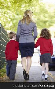 Mother Walking To School With Children On Way To Work